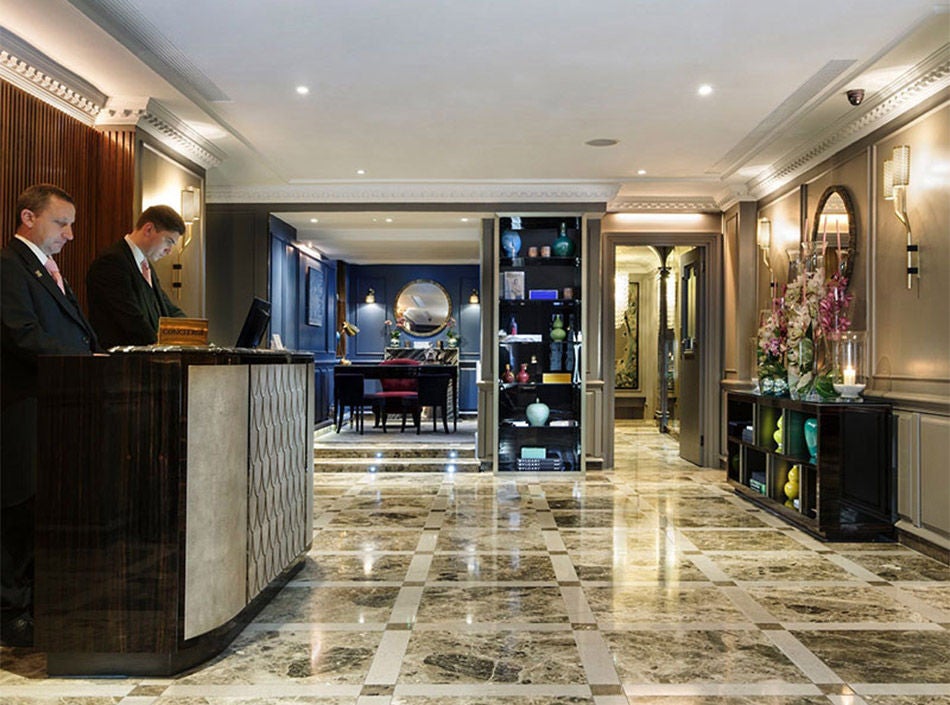 Elegant Georgian townhouse hotel in London's Mayfair, featuring classic red brick facade, white window frames and luxury entrance