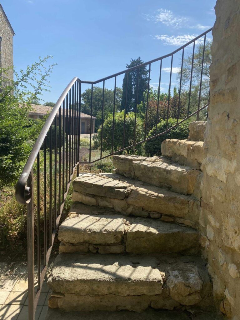 Elegant stone farmhouse with lavender fields, rustic French shutters, and sun-drenched terrace at luxurious boutique hotel in Provence countryside