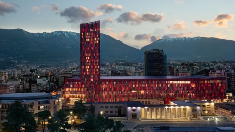 Modern luxury hotel with glass facade, illuminated 