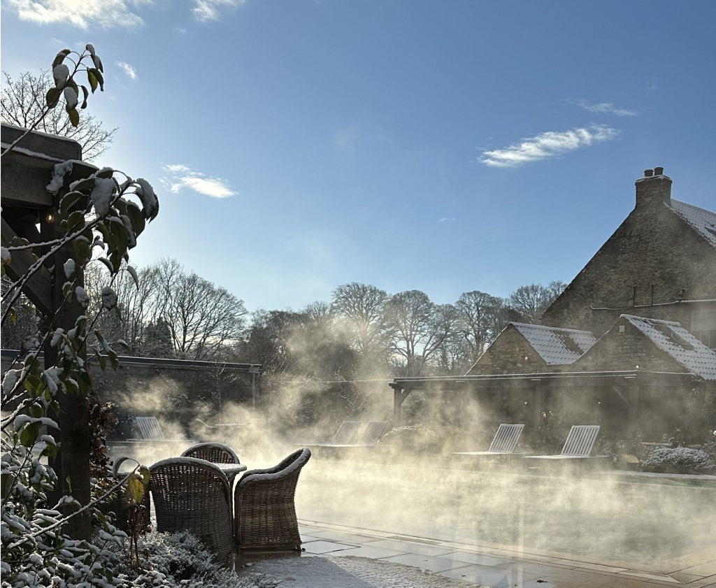 Elegant stone manor house at scenic countryside retreat with manicured gardens, showcasing refined architectural details of luxury hospitality venue