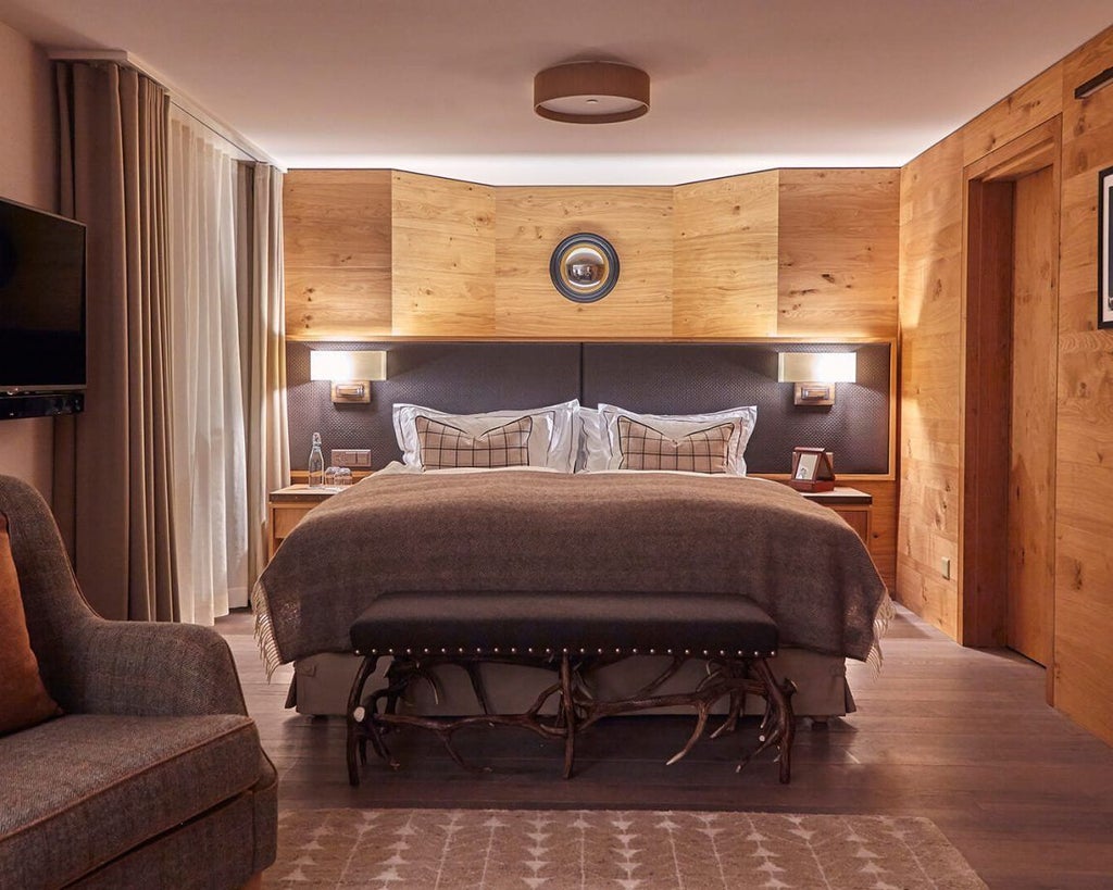 Luxurious alpine-style double room with wooden paneling, plush white bedding, mountain view, and elegant Swiss design highlighting natural textures and warm tones.