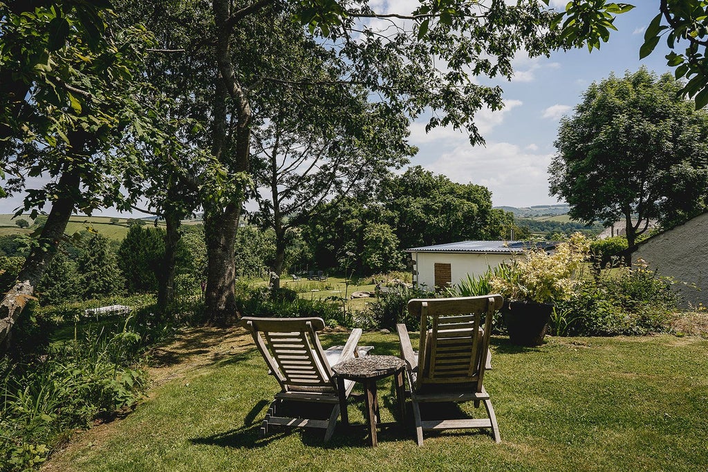 Rustic stone farmhouse nestled in lush Devon countryside, featuring traditional architectural details and serene pastoral landscape with rolling green fields.