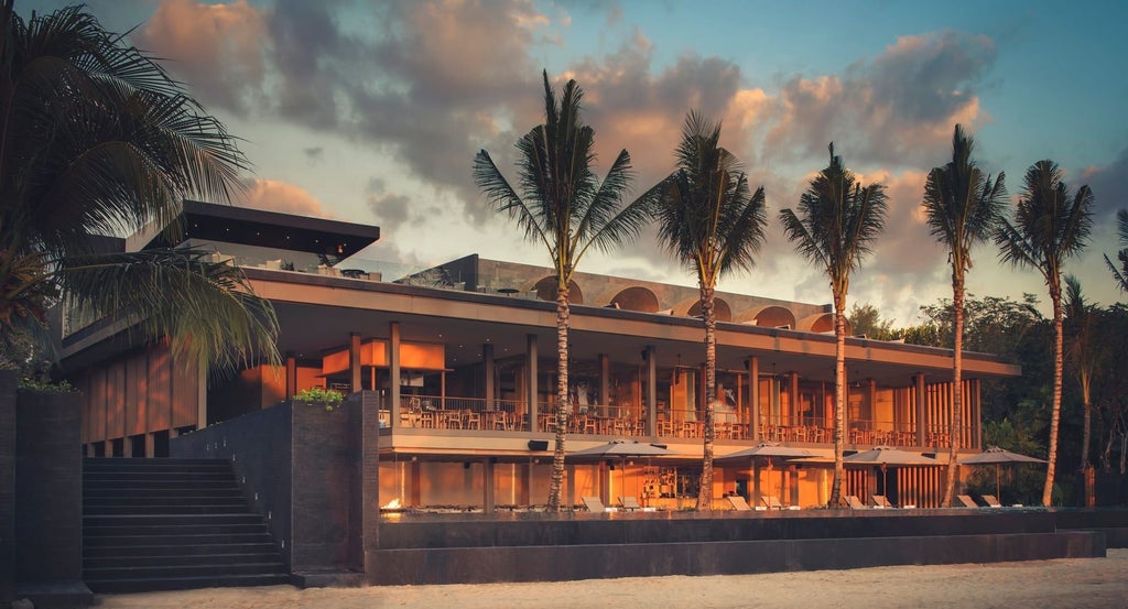 Luxurious oceanfront Anantara Layan resort with infinity pool overlooking Andaman Sea, surrounded by tropical gardens at sunset