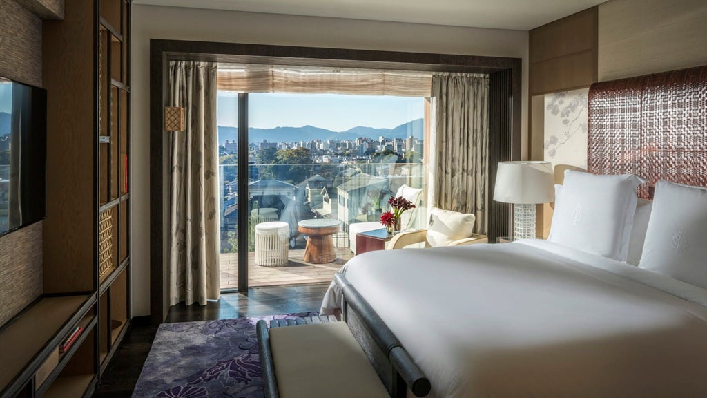 Elegant corner suite at Four Seasons Kyoto with panoramic windows, modern furnishings, and traditional Japanese design elements