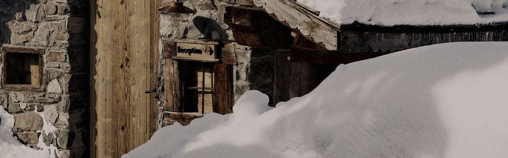 Luxurious wooden alpine chalet nestled in snowy French mountains, featuring warm glowing windows and elegant rustic architectural design at dusk