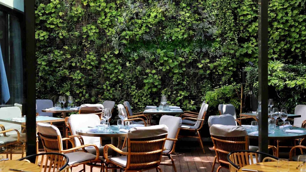 Elegant boutique hotel exterior in Paris with warm stone facade, Art Deco-inspired windows, and soft evening lighting casting a luxurious glow