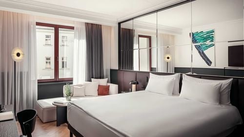 Luxurious executive suite with elegant decor, plush king bed, and private balcony overlooking Prague's historic cityscape from Hotel Almanac X Alcron