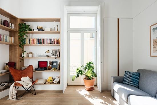 Modern two-bedroom apartment in Lisbon with sleek design, expansive windows, minimalist furniture, and warm natural lighting in neutral tones.