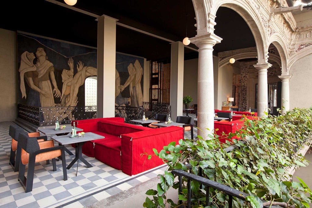 Luxurious colonial-style hotel lobby with high ceilings, ornate stone archways, elegant furniture, and warm lighting in downtown Mexico City