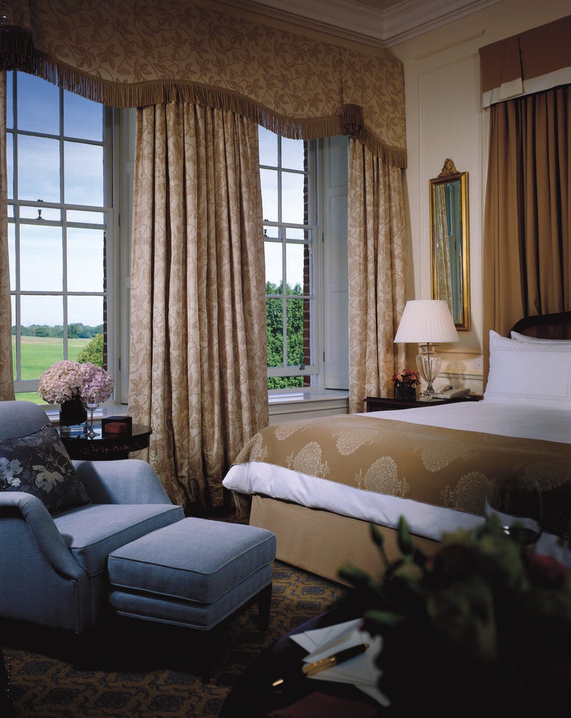 Historic British manor house hotel with Georgian facade, manicured gardens, and scenic countryside views surrounded by estate lands