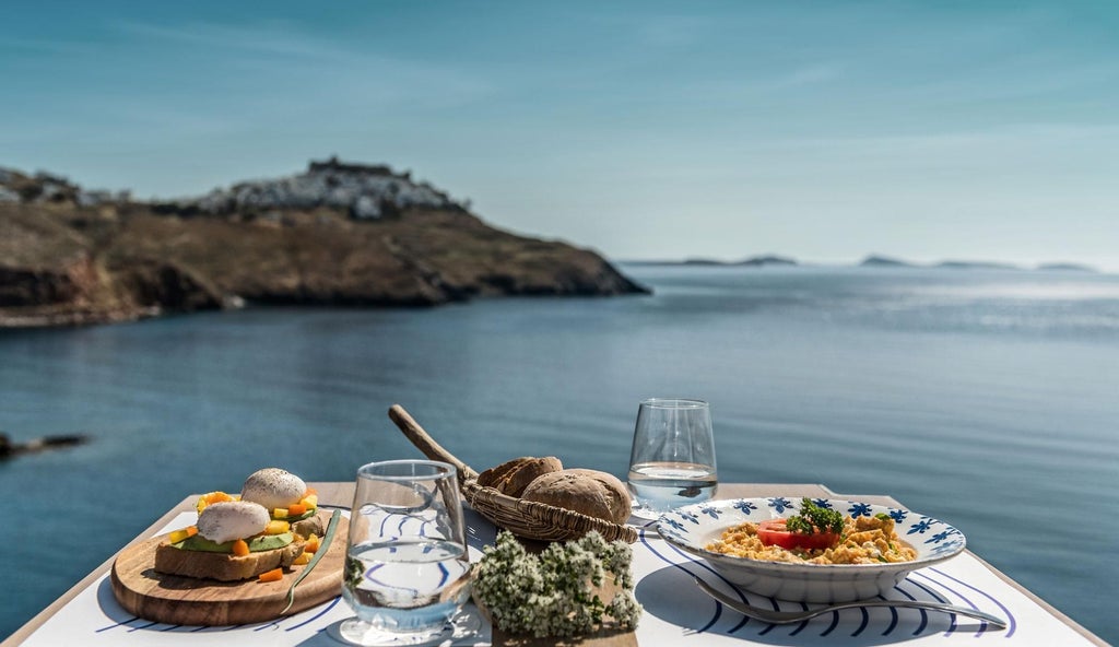 Luxurious white-washed Greek suite with blue accents, overlooking scenic Aegean Sea, featuring minimalist design and elegant Mediterranean architectural details.