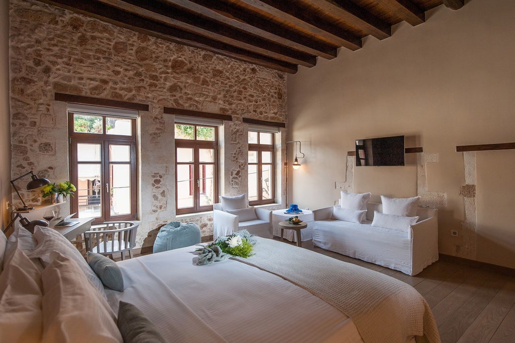 Elegant white and blue Superior Suite at Serenissima Boutique Hotel, featuring minimalist design, plush bedding, and stunning Aegean Sea view through large windows.