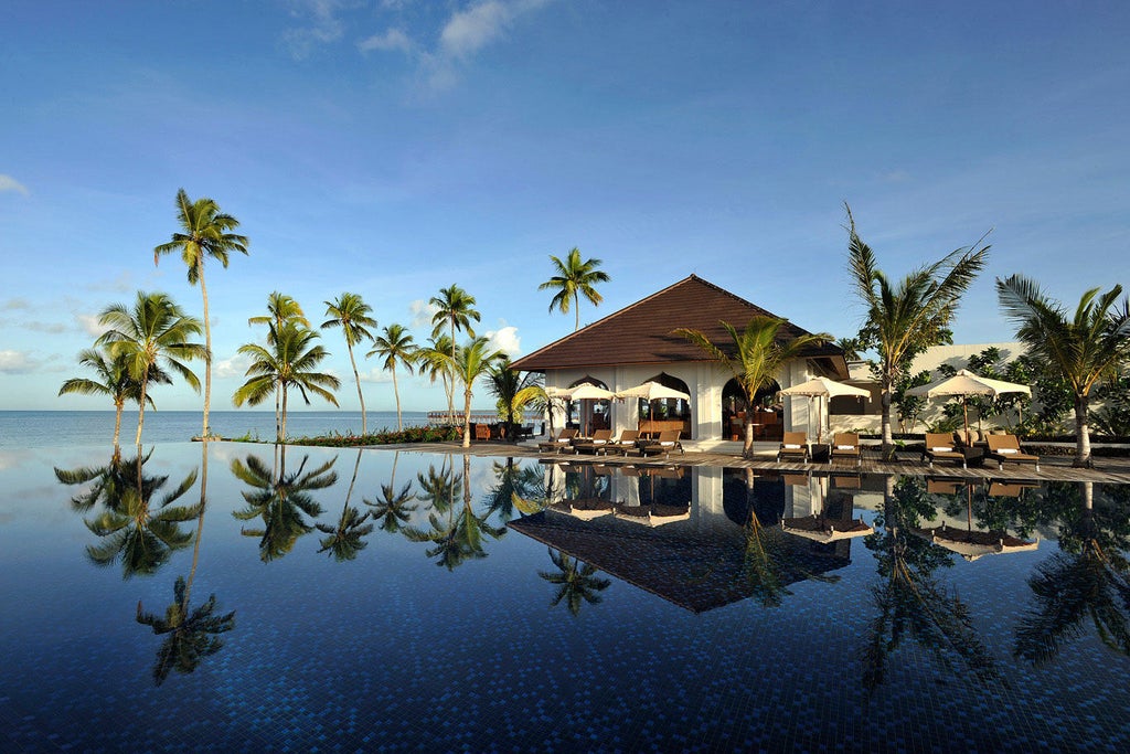 Oceanfront villa with private infinity pool at The Residence Zanzibar, surrounded by tropical gardens and swaying palm trees