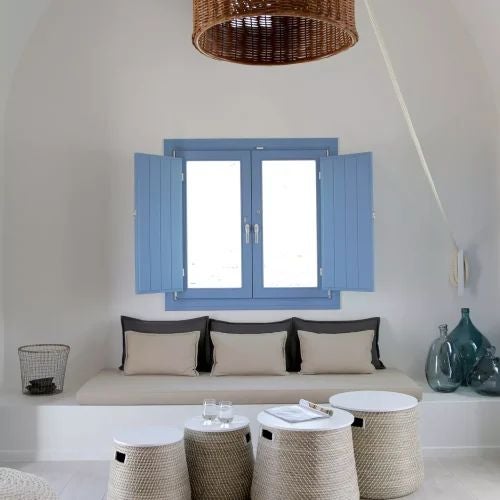 Luxurious white-washed Cycladic villa with blue-domed roof, private terrace overlooking Aegean Sea, elegant Mediterranean design with traditional Greek architectural elements