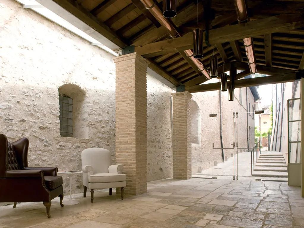 Elegant stone facade of historic Palazzo Seneca hotel nestled in Umbrian landscape, showcasing Renaissance architecture and timeless Italian luxury