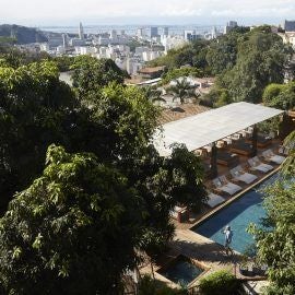 Luxurious colonial-style hotel with white facade, lush tropical gardens, and elegant architecture nestled in the vibrant Santa Teresa neighborhood of Rio de Janeiro