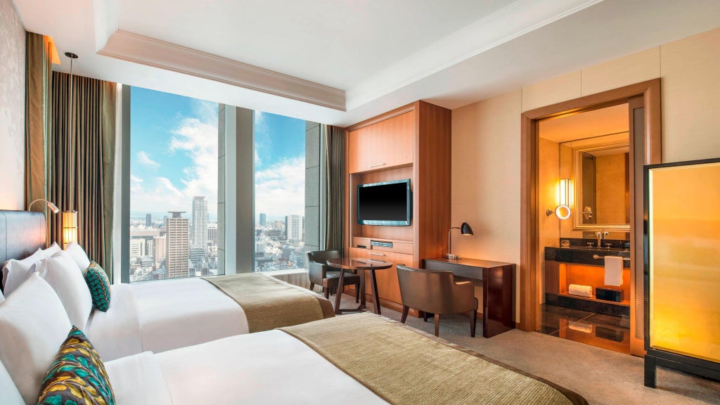 Elegant deluxe hotel room at The Scenset Hotel Osaka, featuring plush king bed, city skyline view, modern Japanese design with sleek furnishings and soft neutral tones