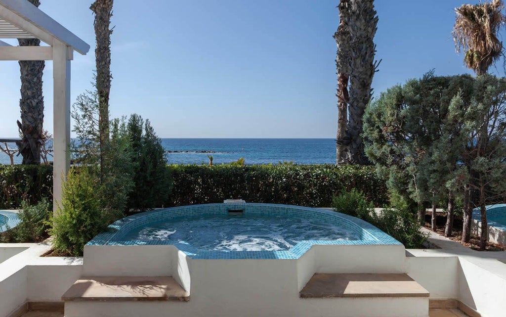 Luxurious garden studio suite with modern whirlpool, elegant furnishings, and soft natural lighting in a serene Cyprus hotel setting