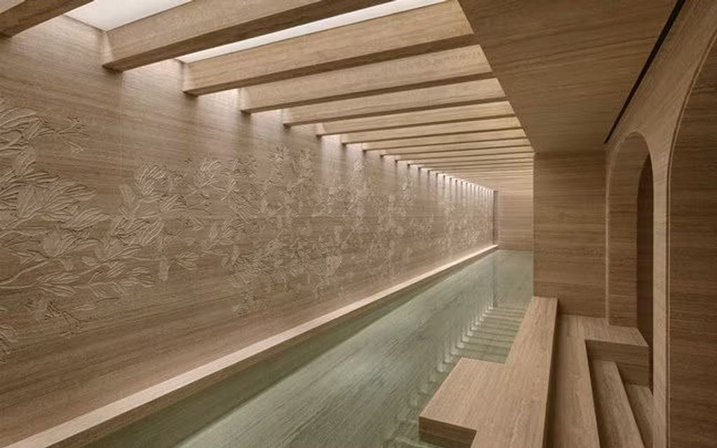 Interior entrance of Six Senses Rome hotel showcasing elegant marble columns, dramatic arched ceilings, and warm ambient ligh