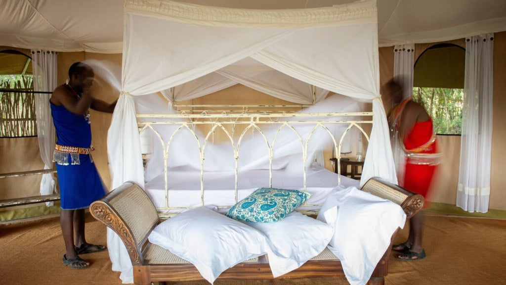 A luxurious safari tent overlooking the Mara plains, with canvas walls, wooden deck, and elegant outdoor furniture at sunset