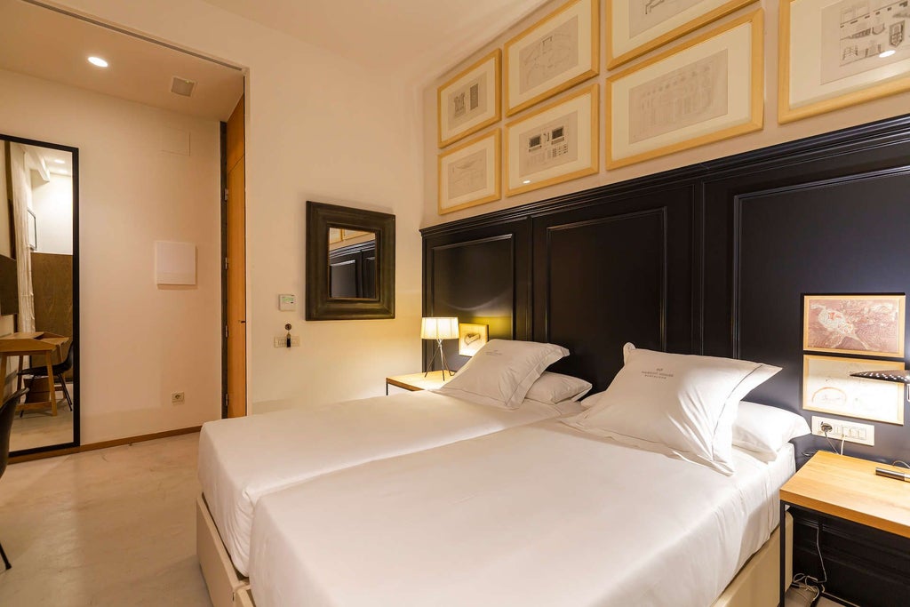 Elegant deluxe hotel room with plush white bedding, minimalist design, warm wood tones, and soft natural light in a boutique Barcelona accommodation