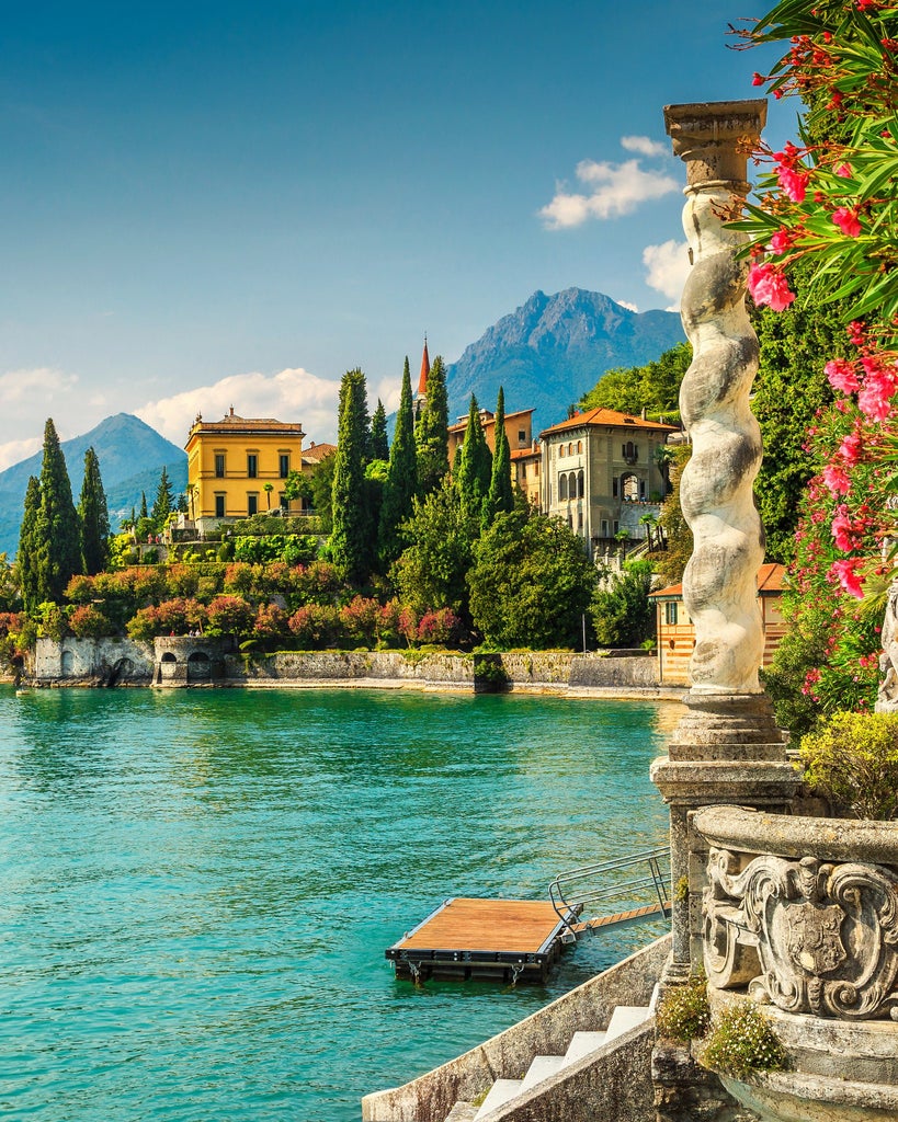 Scenic Lake Como reflecting snow-capped Italian Alps, with elegant lakeside villas nestled among cypress trees and manicured gardens