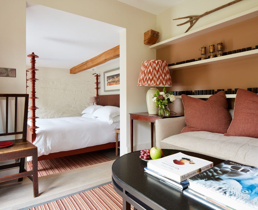 Elegant suite with plush bedding, antique wooden furniture, soft cream walls, and warm lighting at Grove of Narberth's Lovage Room in verdant Welsh countryside