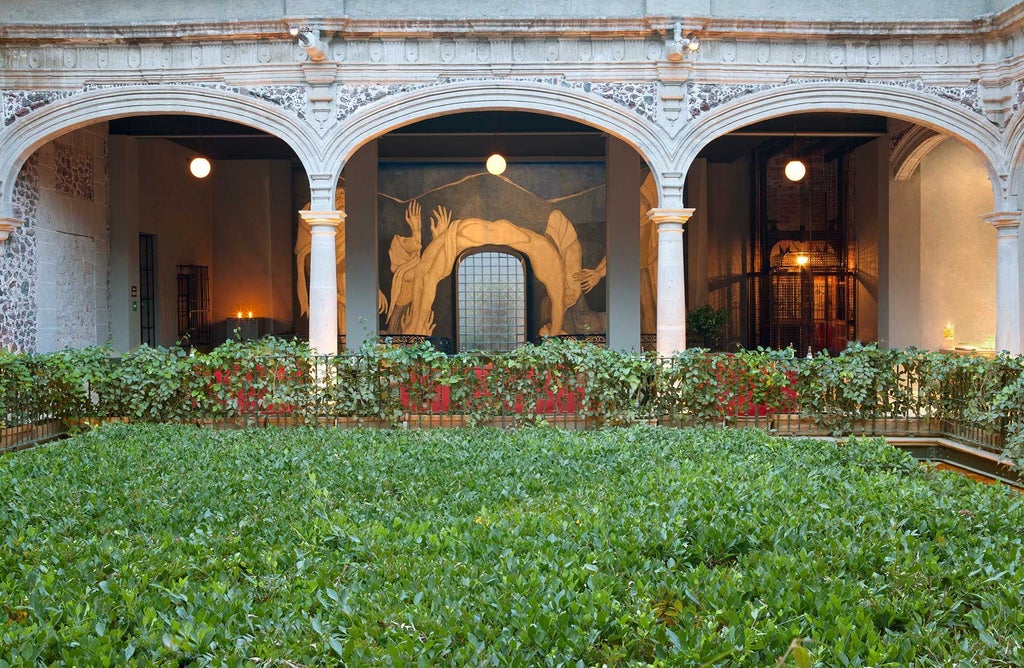 Elegant colonial-style hotel lobby in downtown Mexico City, featuring ornate chandeliers, restored historic architecture, and warm terracotta color palette