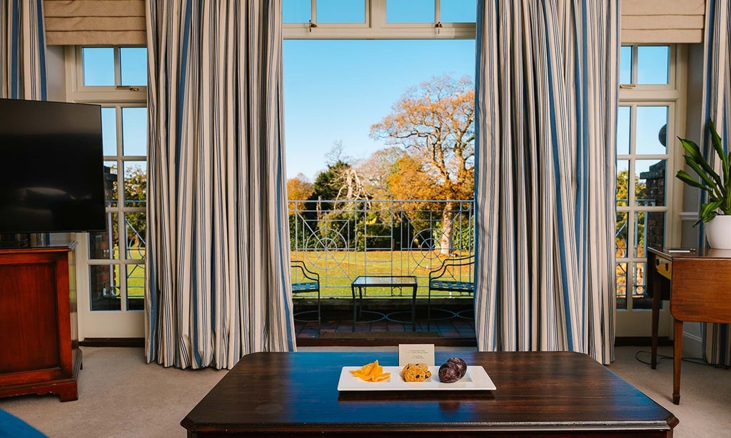 Luxurious hotel room at Chewton Glen with elegant decor, plush bedding, and expansive views of manicured croquet lawn in scenic United Kingdom countryside