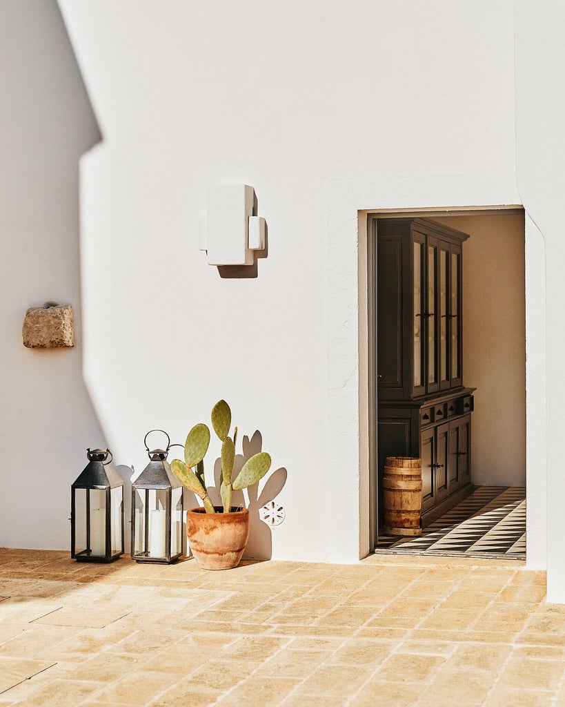 Rustic-chic Italian farmhouse with stone walls, terracotta roof, and lush olive grove, nestled in scenic Puglia countryside at golden hour