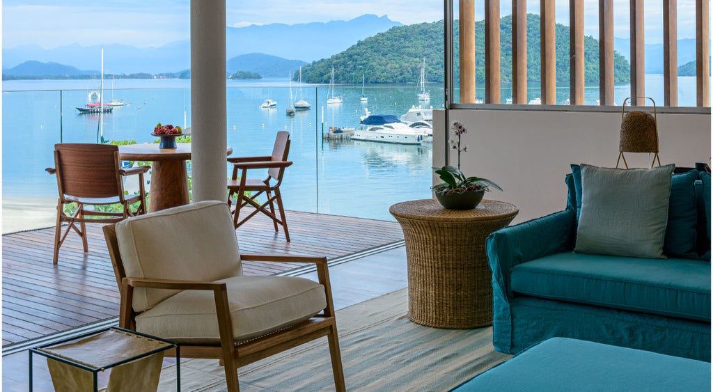 Luxury beachfront hotel in Angra dos Reis with infinity pool overlooking calm bay, modern architecture and lush mountains beyond