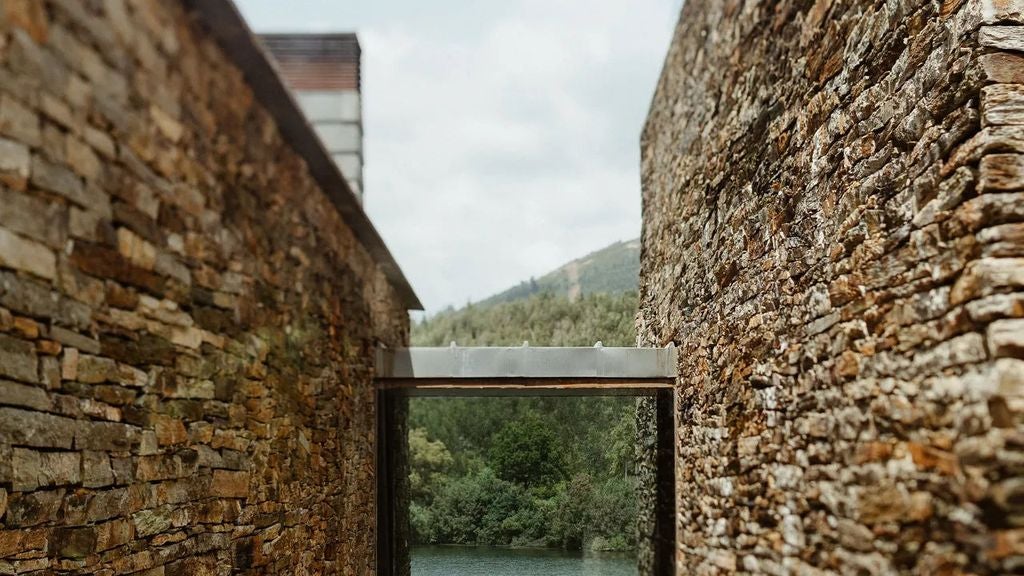 Luxurious infinity pool overlooking Douro Valley's terraced vineyards, with modern sunbeds and panoramic views of the river and mountains