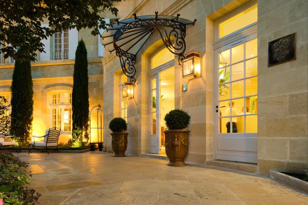 Historic French hotel de Pavie with ornate stone facade, arched windows, and charming ivy-covered walls in a cobblestone courtyard