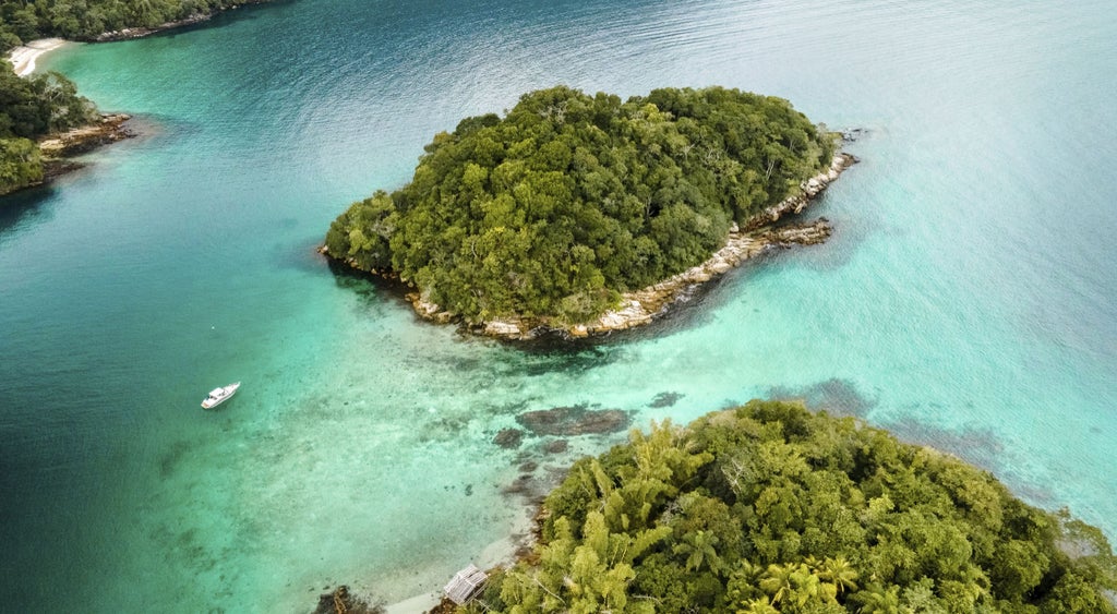 Luxurious oceanfront hotel with infinity pool overlooking mountains and yachts in a private bay at Angra dos Reis, Brazil