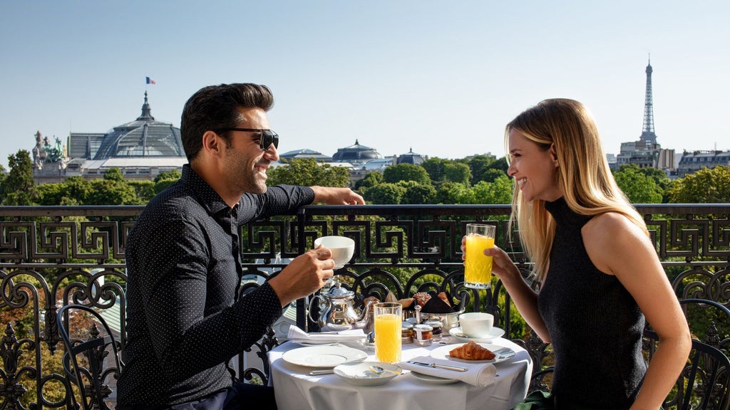 Elegant Parisian luxury hotel with neoclassical facade, ornate balconies, and lush garden terrace overlooking the city's iconic architectural landscape