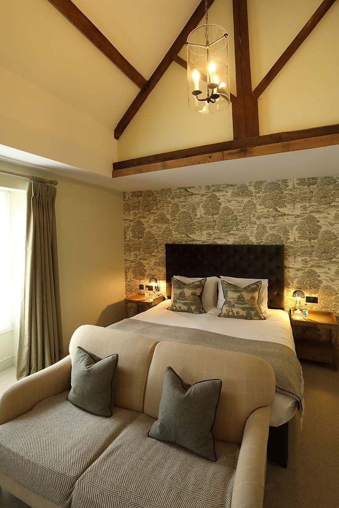 Elegant feature room at Kings Head Hotel, featuring plush bedding, sophisticated decor, warm lighting, and refined British countryside charm