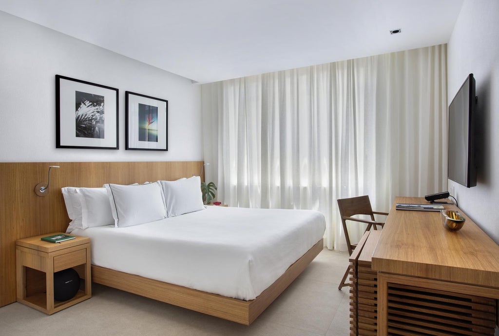 Elegant contemporary hotel room with ocean view, minimalist design, crisp white linens, modern furniture, and expansive floor-to-ceiling windows overlooking Brazilian coastline