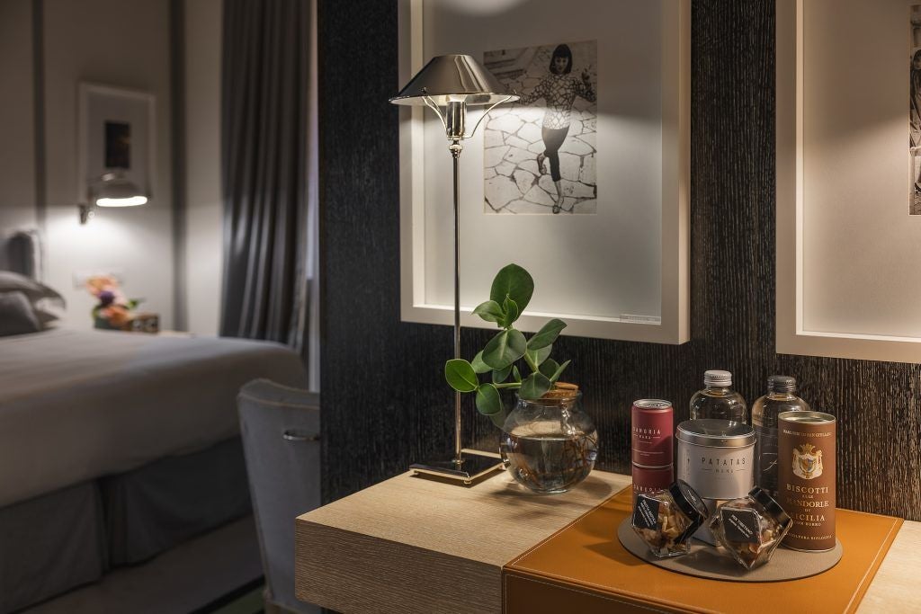 Elegant luxury hotel suite in Portrait Roma, featuring refined Italian decor, plush bedding, and soft ambient lighting with panoramic city views