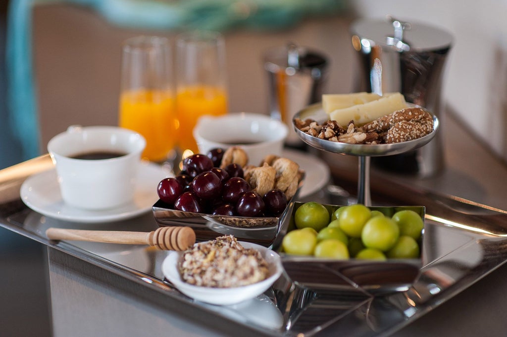 Elegant superior suite with private terrace overlooking azure Aegean waters, featuring modern minimalist decor and plush white bedding at luxury boutique hotel