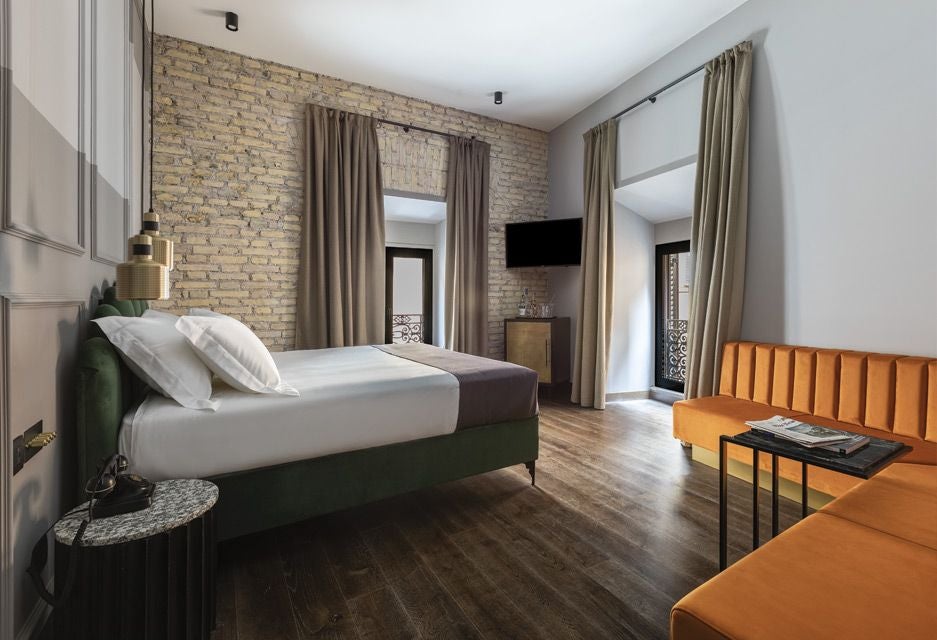 Modern Italian luxury hotel room with elegant neutral tones, plush white bedding, minimalist design, and soft ambient lighting at Chapter Roma hotel.