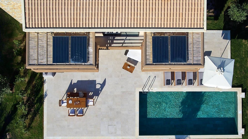 Luxurious seafront suite with minimalist white decor, wooden accents, and panoramic Aegean Sea view from private balcony at boutique Greek island resort