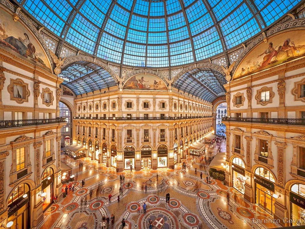 Opulent lobby of scenset Galleria Vik hotel in Milan, featuring gleaming marble floors, elegant design, and a grand chandelier with Italian architectural splendor