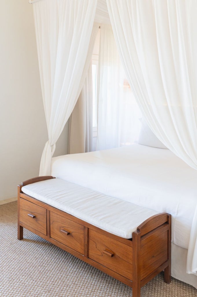 Elegant whitewashed Spanish hotel room with panoramic Mediterranean sea view, minimalist design, and rustic stone walls at Torralbenc resort