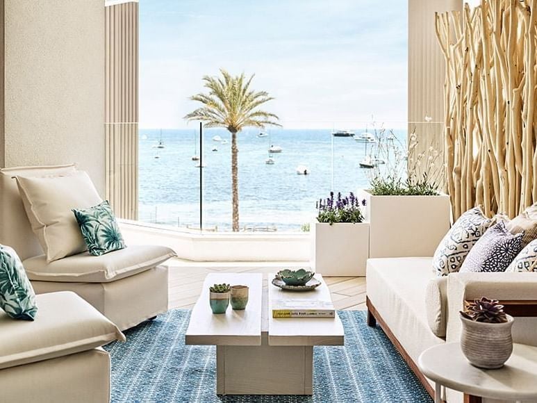 Luxurious Nobu Hotel Ibiza Bay rooftop junior suite with crisp white linens, modern design, and panoramic coastal views of Spain's azure waters