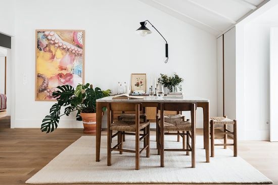 Elegant traditional Portuguese apartment with blue tile walls, modern minimalist furnishings, and large windows overlooking Lisbon's charming historic streetscape