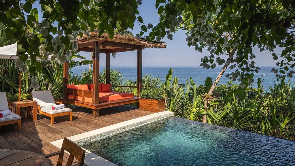 Luxurious Mandaka Surf Villa at NIHI Sumba, featuring expansive ocean views, teak wood furnishings, and an infinity pool overlooking lush Indonesian landscape