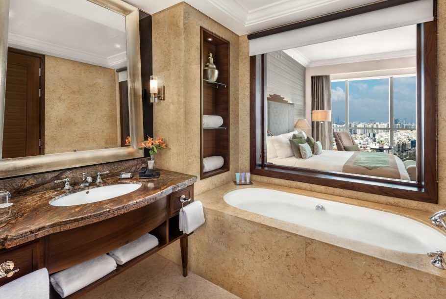 Luxurious Dusit Club Room at Dusit Thani Abu Dhabi, featuring modern elegant decor, plush king bed, city skyline view, and sophisticated neutral color palette