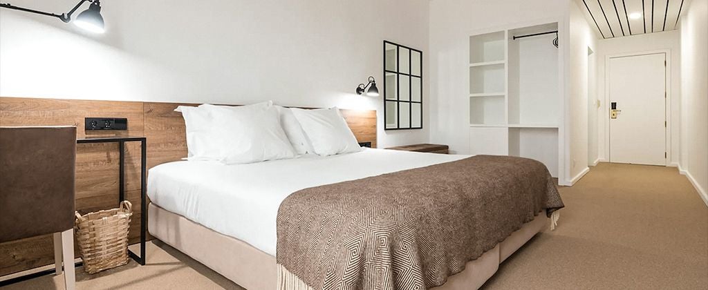 Elegant double room with garden view at Lamego Hotel & Life, featuring plush white bedding, modern decor, and verdant Portuguese landscape beyond large windows