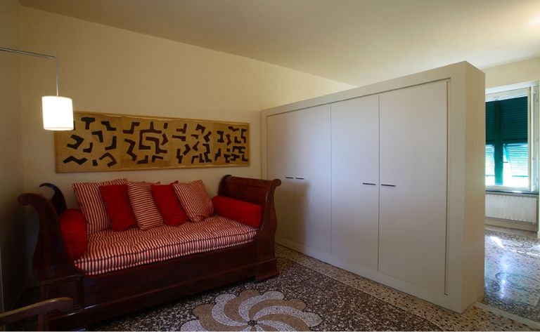 Elegant Italian villa bedroom with rosemary-inspired decor, plush white linens, rustic wooden furniture, and soft natural light streaming through arched windows