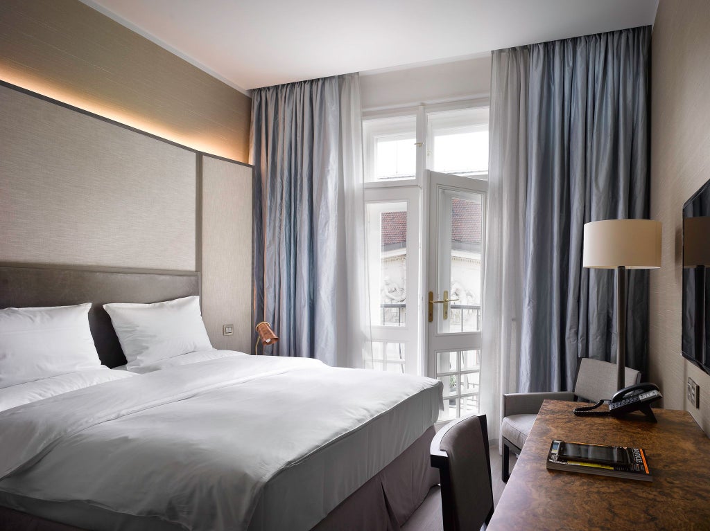 Elegant contemporary hotel room with plush king bed, rich wooden floors, luxurious neutral color palette, and sophisticated Czech design details